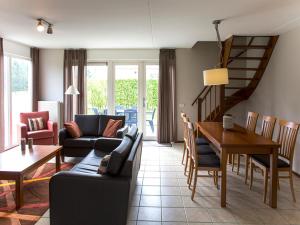 una sala de estar con un sofá y una mesa en Charming forest house surrounded by a garden, en Heel