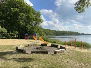 WildbergHoliday house in Wildberg with 1 bedroom的一个带火坑和滑梯的游乐场