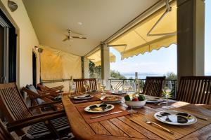 un tavolo in legno con piatti di bicchieri da cibo e vino di Villa Aeolos a Barbati