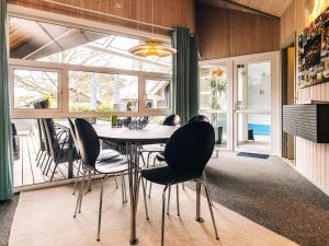 Smidstrup5 star holiday home in Gilleleje的餐厅里有一张桌子和几把椅子