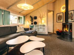 Smidstrup5 star holiday home in Gilleleje的客厅配有沙发、桌子和壁炉