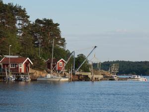 Tanum4 person holiday home in Tanumshede的码头上有房屋，水里停着一艘船。