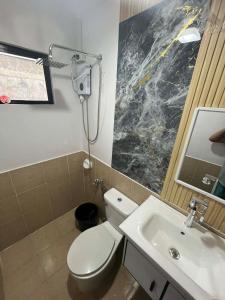 a bathroom with a white toilet and a sink at Eko's Crib Unit 30 in Sampong