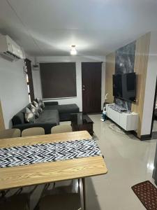 a living room with a couch and a flat screen tv at Eko's Crib Unit 30 in Sampong