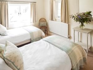 een slaapkamer met twee bedden en een raam bij Fursdon Cottage in Cadbury +3 foto's