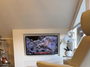 un soggiorno con una TV a schermo piatto su una parete di Am Wäldchen 8 Comfortable holiday residence a Vöhl