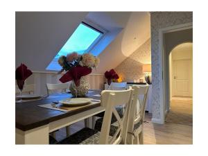 una sala da pranzo con tavolo e vaso di fiori di Am Wäldchen 8 Comfortable holiday residence a Vöhl