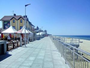 una passerella su una spiaggia con un edificio e l'oceano di Spacious holiday homes with terraces, Sarbinowo a Sarbinowo