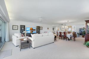 a living room with two white couches and a table at Beachcomber A101 in Sanibel