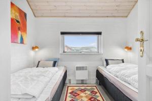 duas camas em um pequeno quarto com janela em 461-Hvide-Sande-Tingodden-152 em Hvide Sande