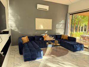 a living room with a blue couch and a table at Villa Five Collection - Private Luxury & Heated Pool in Ouled Moumene