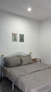a bed in a bedroom with two pictures on the wall at Trong Roomstays in Terong