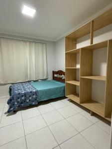 een slaapkamer met een bed en enkele planken bij Casa de praia in Barra Velha