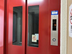 a red door with a no smoking sign on it at シェール松岡 in Ōdōri