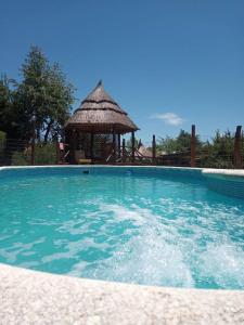 una piscina con gazebo sullo sfondo di Cabañas del IntiCo a Arroyo de Los Patos