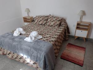 a bedroom with two beds and two towels at Casa Tina in Neuquén