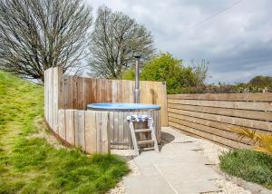 Una valla de madera con una mesa azul y un taburete. en Maesbury Den, en Radstock 6 fotos más