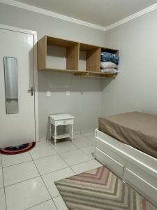 ein kleines Schlafzimmer mit einem Bett und einem kleinen Tisch in der Unterkunft Casa de praia in Barra Velha