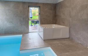 um quarto com uma banheira e uma janela em Lovely Home In Ebeltoft em Femmøller