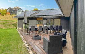 um deque com uma mesa, cadeiras e um guarda-sol em Lovely Home In Ebeltoft em Femmøller mais 12 fotografias