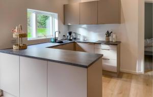 uma cozinha com armários brancos e uma bancada preta em Lovely Home In Ebeltoft em Femmøller