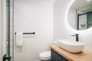 een badkamer met een witte wastafel en een spiegel bij LAO LOFT 105 by Gestion ELITE in Mont-Tremblant