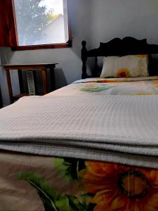 Un dormitorio con una cama con un edredón de flores. en Kóten Naj, en Chicanna