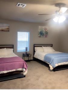 una camera da letto con due letti e un ventilatore a soffitto di The Relaxed Place 