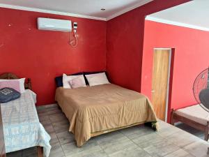 a bedroom with a bed in a red wall at Departamento Temporal en Villa Carlos Paz in Villa Carlos Paz