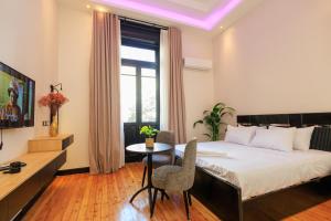 カイロにあるThe KMT Collection Hotelのベッドとテーブルと窓のある寝室