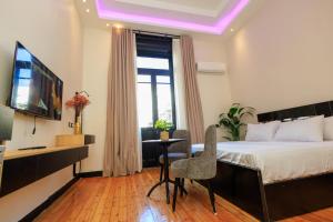 カイロにあるThe KMT Collection Hotelのベッド、テレビ、テーブルのある寝室