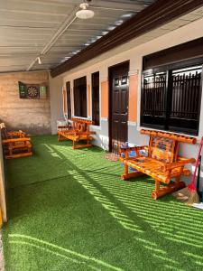 a room with green carpet and wooden benches on the floor at Eko's Crib Unit 30 in Sampong