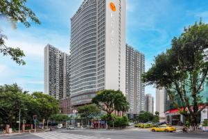 a tall building in a city with a street at JOYINN HOTEL Guangzhou Zoo Shaheding Metro Branch & Guangzhou Beijing Road Pedestrian Street & Canton Fair Nearby 桔迎酒店-广州动物园沙河顶地铁站店 in Guangzhou