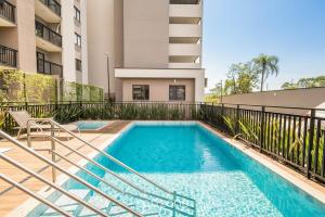 a swimming pool in front of a building at Aptos completos em prédio com piscina a 400m da Praia de Piçarras - BACs in Piçarras