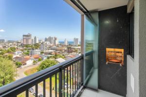 a balcony with a view of a city at Aptos completos em prédio com piscina a 400m da Praia de Piçarras - BACs in Piçarras
