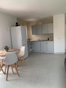 una cucina con un tavolo e un frigorifero bianco di Minerva 518- Garden View a Benalmádena
