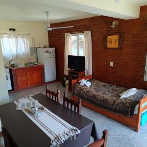 una habitación con una cama y una mesa con sillas en Cabañas Peñihue, en Carpintería