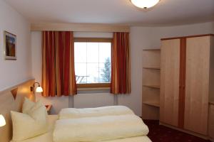 1 dormitorio con 2 camas y ventana en Haflingerhof, en Fiss