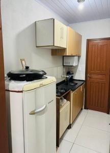 una cucina con frigorifero bianco e armadietti in legno di Apartamento 2 a Arroio do Silva Altre 3 foto