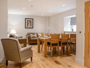 Un comedor y una sala de estar con mesa y sillas. en The Old Mill, en Linlithgow