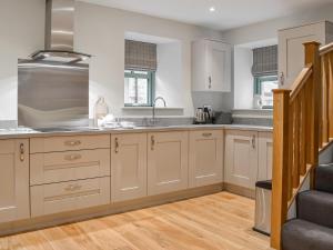 Una cocina con gabinetes blancos y una escalera. en The Old Mill, en Linlithgow 19 fotos más