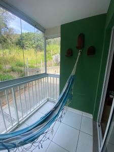 Bom SucessoSerra Stay *Petrópolis*的带阳台的客房内的吊床