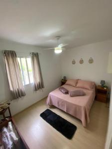 Bom SucessoSerra Stay *Petrópolis*的一间卧室配有一张带粉色床单的床和一扇窗户。