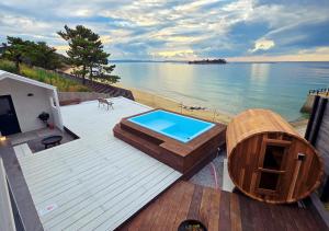 una terraza con piscina y bañera de hidromasaje en Kubikai, en Itoshima