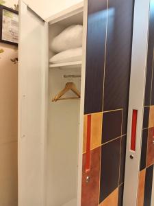 Un armario con una puerta blanca y un estante. en Xybel Studio, en Baguio