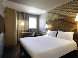 ein Hotelzimmer mit großem Bett und Schreibtisch in der Unterkunft Hotel ibis Porto Gaia in Vila Nova de Gaia