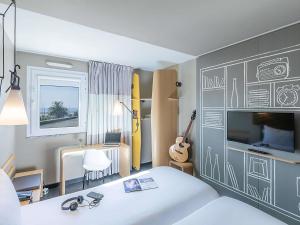 ein Schlafzimmer mit einem Bett und einer Wand mit Zeichnungen darauf in der Unterkunft Hotel ibis Porto Gaia in Vila Nova de Gaia