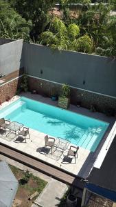 una piscina con quattro sedie e una piscina di Hotel Paraiso Termal a Termas de Río Hondo