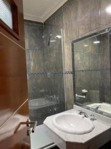 un bagno con lavandino e doccia in vetro di Hotel Paraiso Termal a Termas de Río Hondo