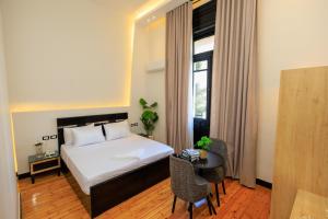 Una habitación de hotel con una cama, una mesa y una ventana. en The KMT Collection Hotel, en El Cairo